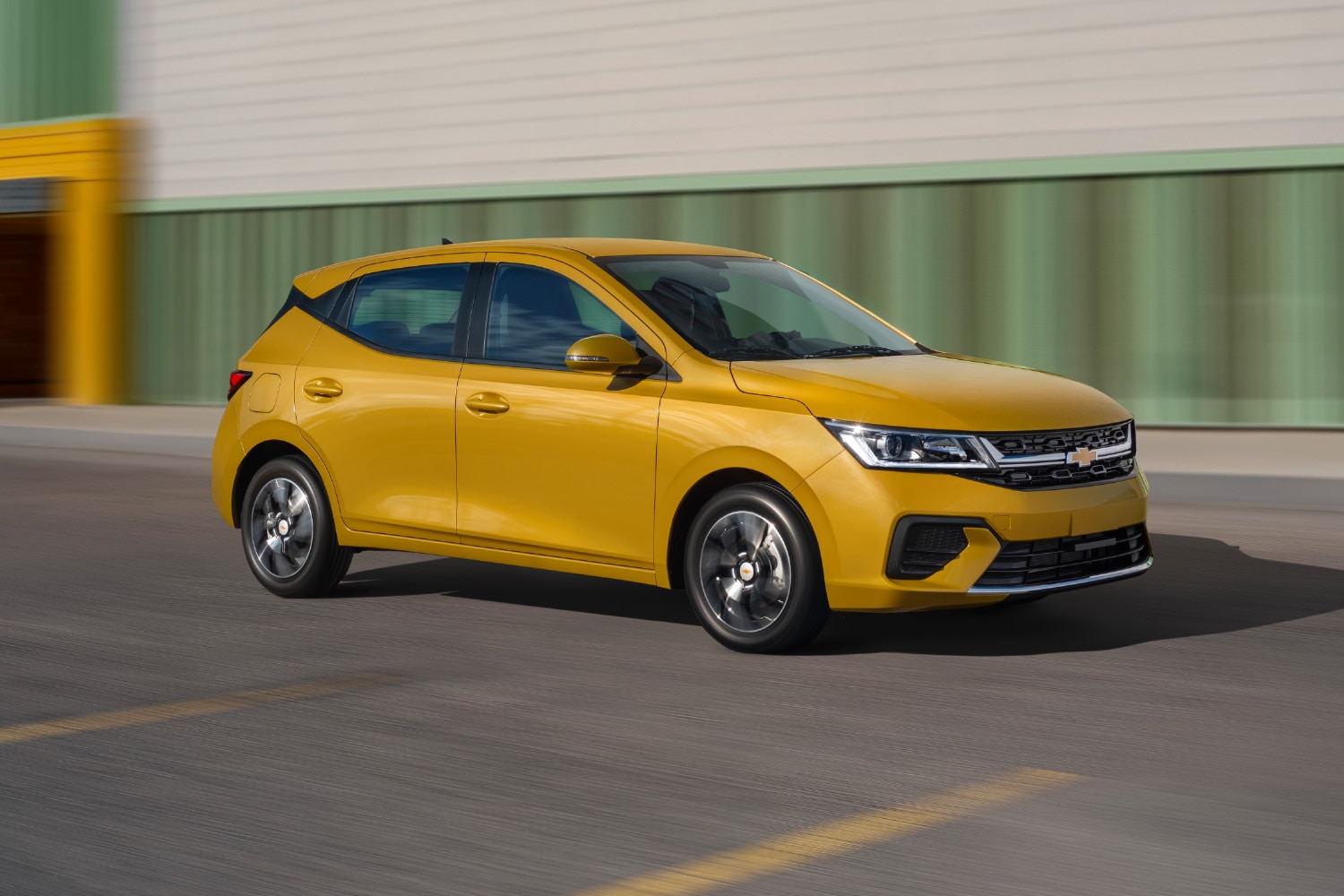 Imagen lateral Chevrolet Aveo Hatchback 2026, nuevo auto compacto 4 puertas con rines de 15 pulgadas en aluminio bitono